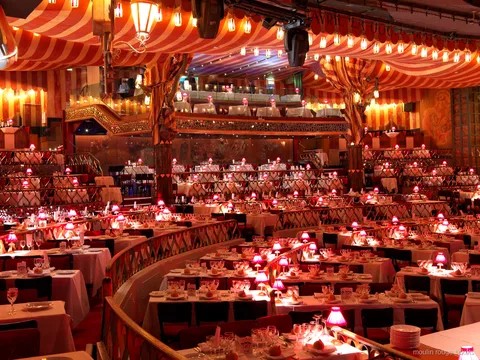 Biglietti Moulin Rouge: la sala del cabaret con soffitto a righe rosse, tavoli a gradoni e lampade rosa