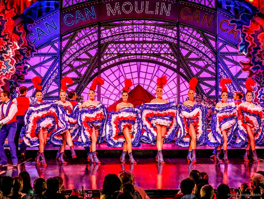 Bailarina de cancán en un salto abierto con falda azul de volantes y su pareja, cena espectáculo Moulin Rouge