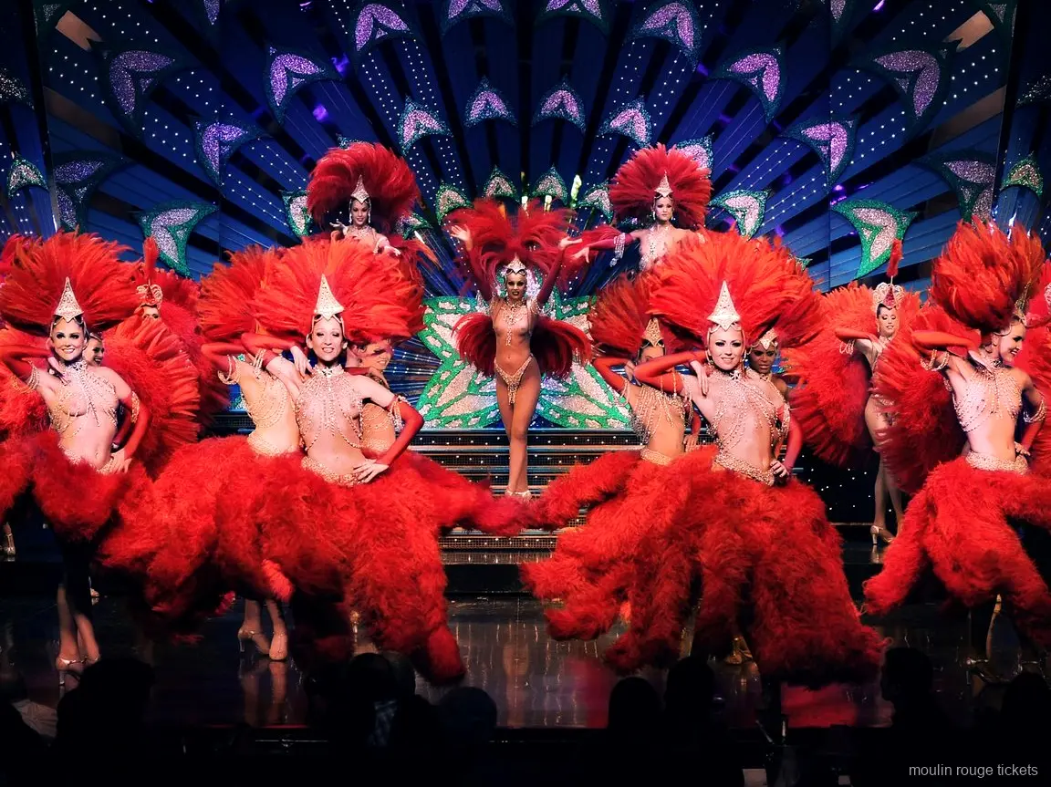 Bailarinas con plumas rojas y tocados brillantes en el escenario, la revista que ves con entradas Moulin Rouge