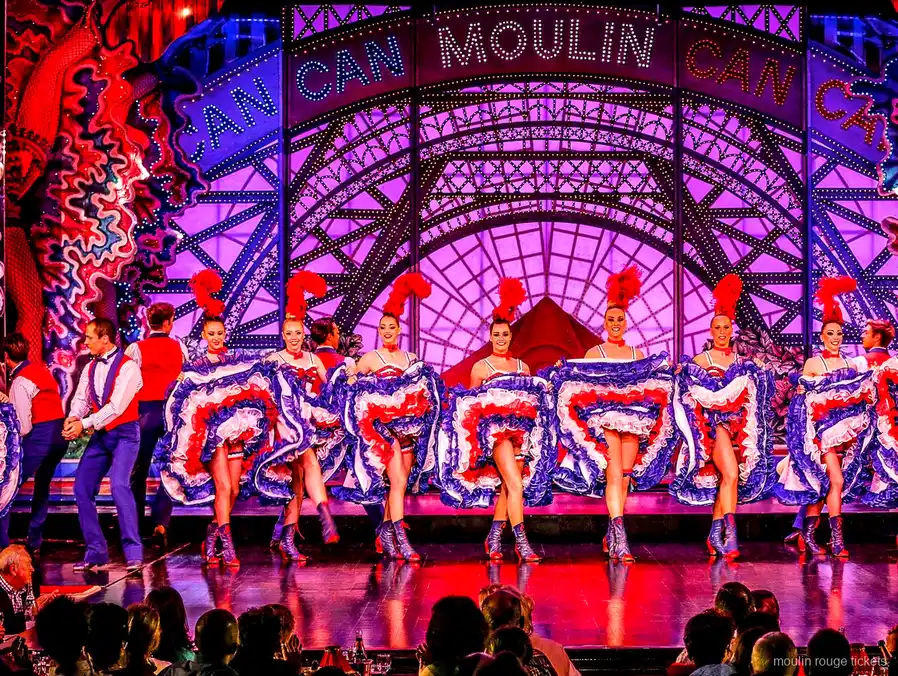 French cancan dancers in ruffled skirts under the Moulin Can Can sign on stage, the show on Moulin Rouge tickets