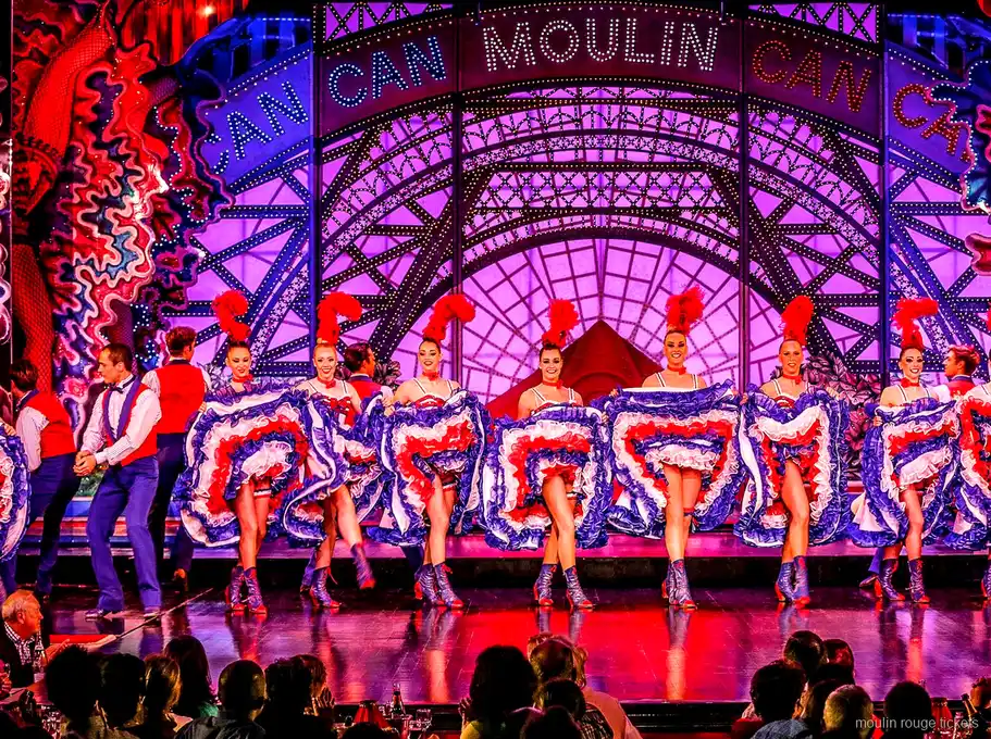 French cancan danseressen in rokken met ruches onder het Moulin Can Can bord, de show met Moulin Rouge tickets