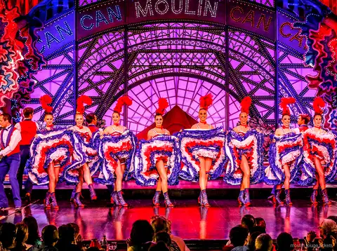 Tancerka kankana w szpagacie w powietrzu w niebieskiej spódnicy z partnerem, bilety Moulin Rouge z kolacją
