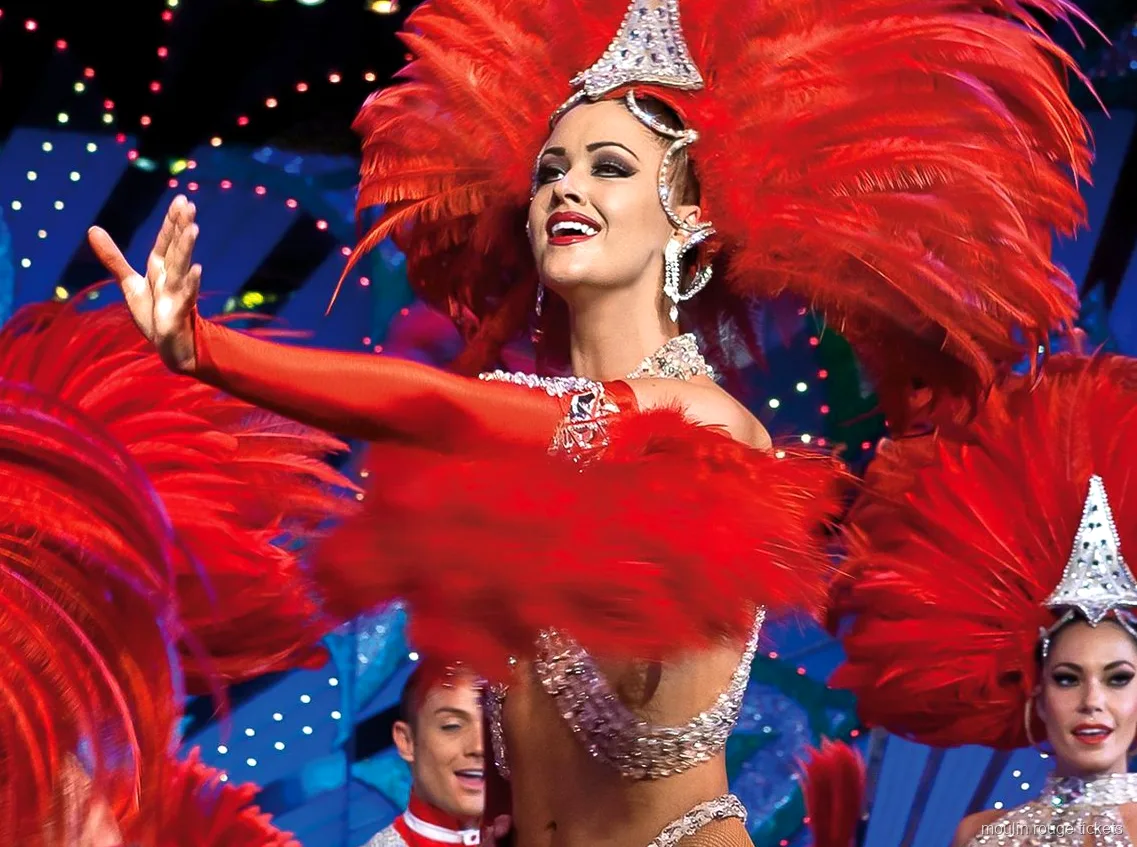 Moulin Rouge biletleri: sahne ışıkları altında kırmızı tüylü başlık ve pullu kostümlü dansçı