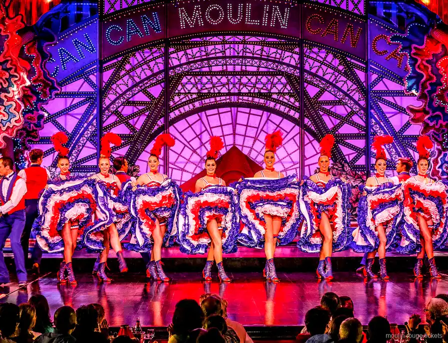 青いフリルスカートで空中開脚を決めるカンカンの踊り子と後ろのパートナー、ムーランルージュ ディナーショー チケットで観る舞台