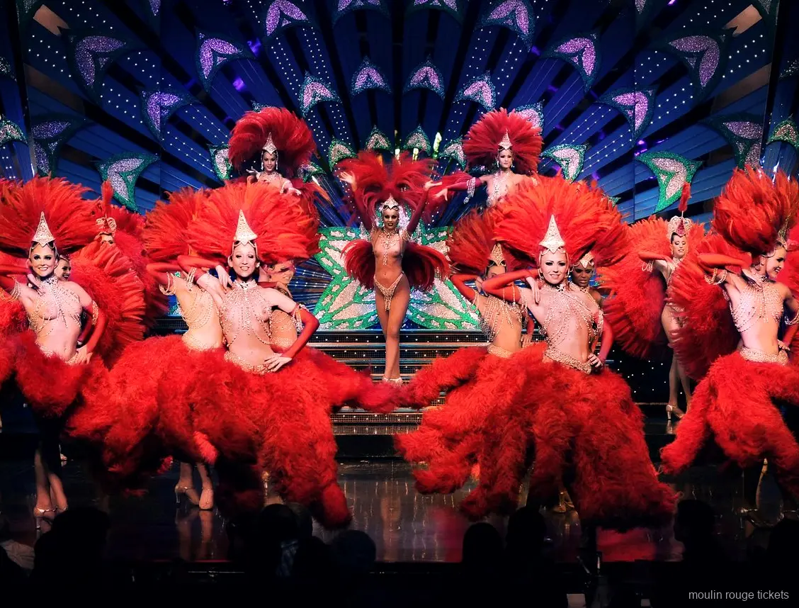 Danseressen in rode verenkostuums en glinsterende hoofdtooien op het podium, de revue met Moulin Rouge tickets
