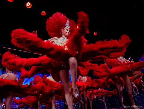 Tänzerinnen wirbeln große rote Federfächer beim hohen Beinwurf, Moulin Rouge Dinner Show Tickets