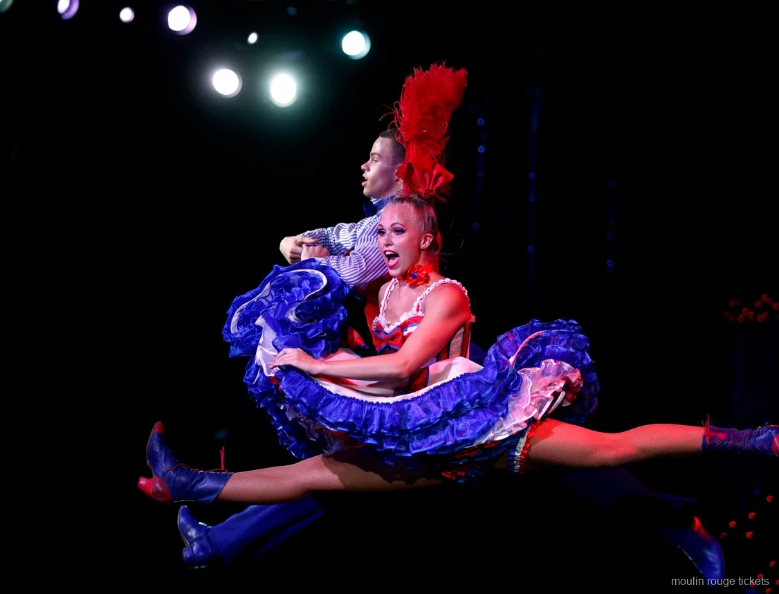 Audience facing the French Cancan line beneath the glowing Moulin sign, Moulin Rouge dinner show tickets