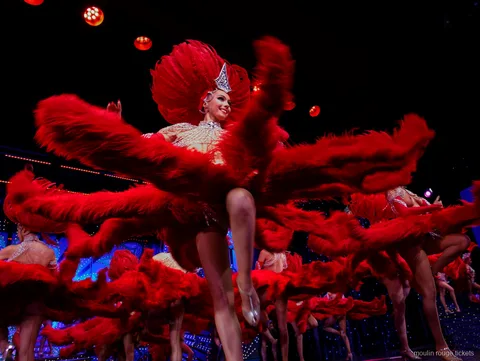 Dansere svinger store røde fjervifter i et højt spark, Moulin Rouge dinner show-billetter