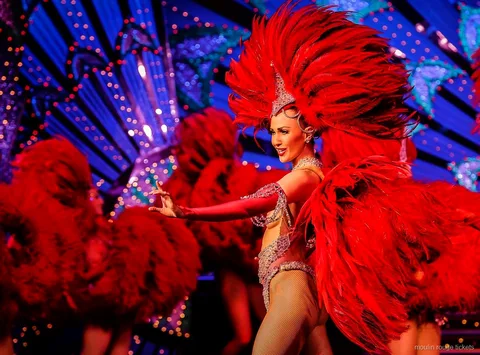 Danser med en stor rød fjervifte foran en blåt oplyst kulisse, Moulin Rouge show-billetter