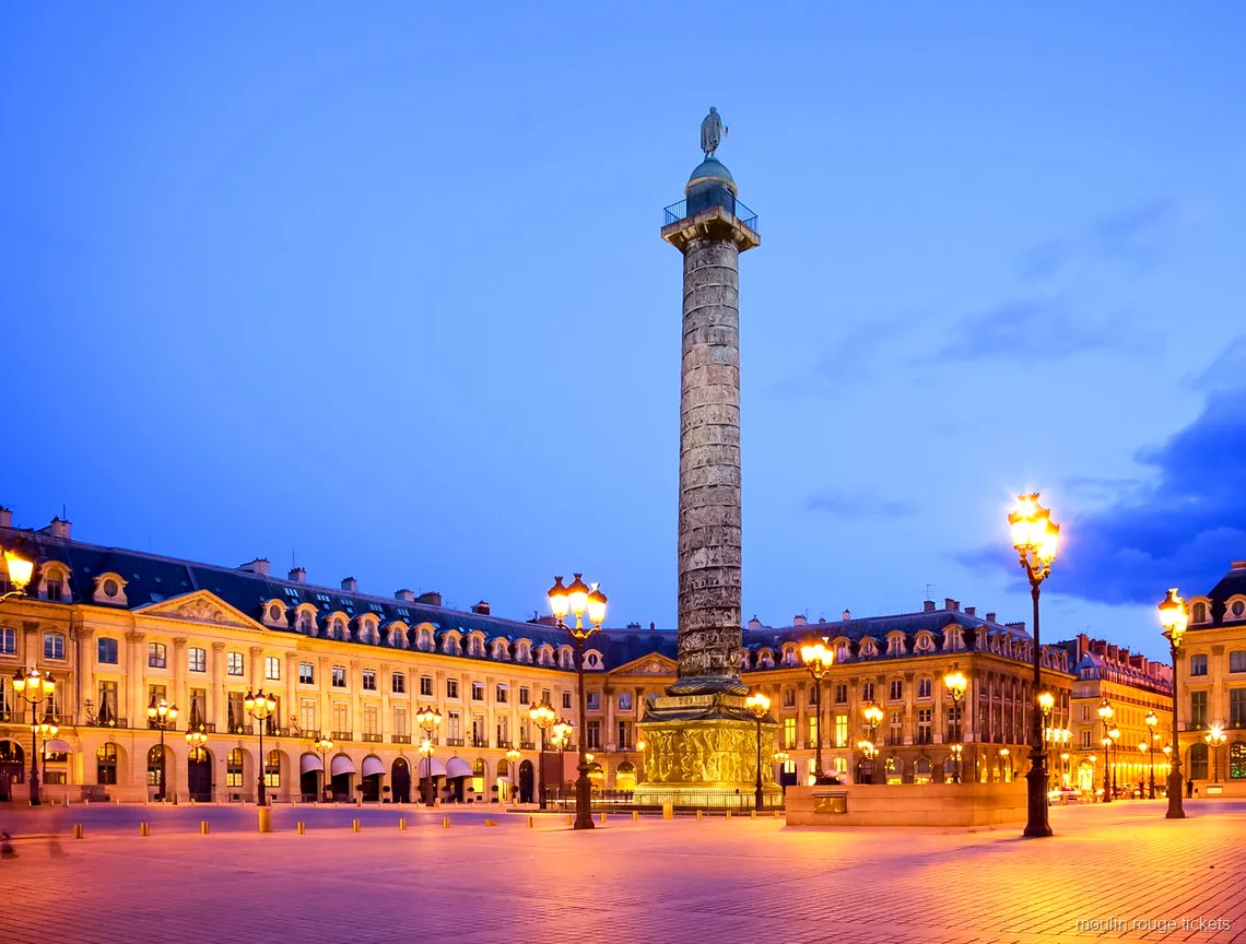 Alacakaranlıkta yüksek sütunu ve yanan sokak lambalarıyla Place Vendôme, Moulin Rouge biletleri turunun durağı